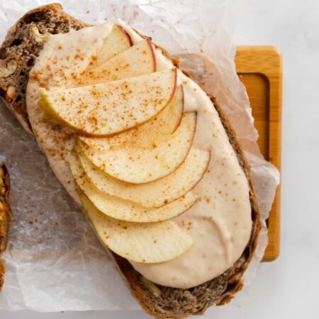 fines tranches de pomme sur une tranche de pain multigrain badigeonnée d'un déliceux beurre de pomme citronné maison