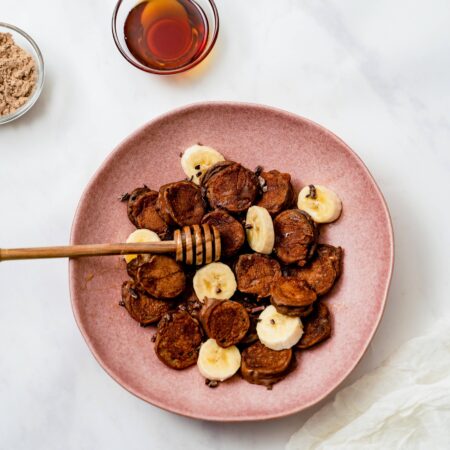 Plat rempli de rondelles de bananes enveloppées de pâte à pancake protéinée au chocolat