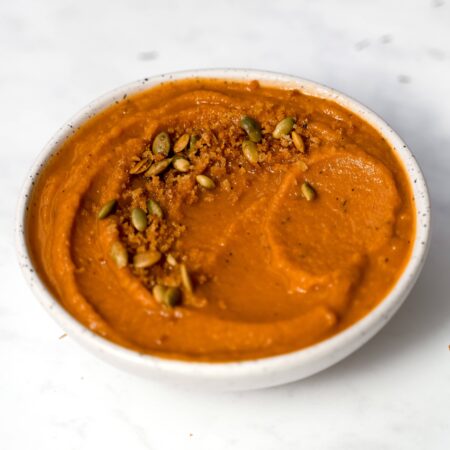 Soupe onctueuse orange avec garniture croustillante aux graines de citrouilles