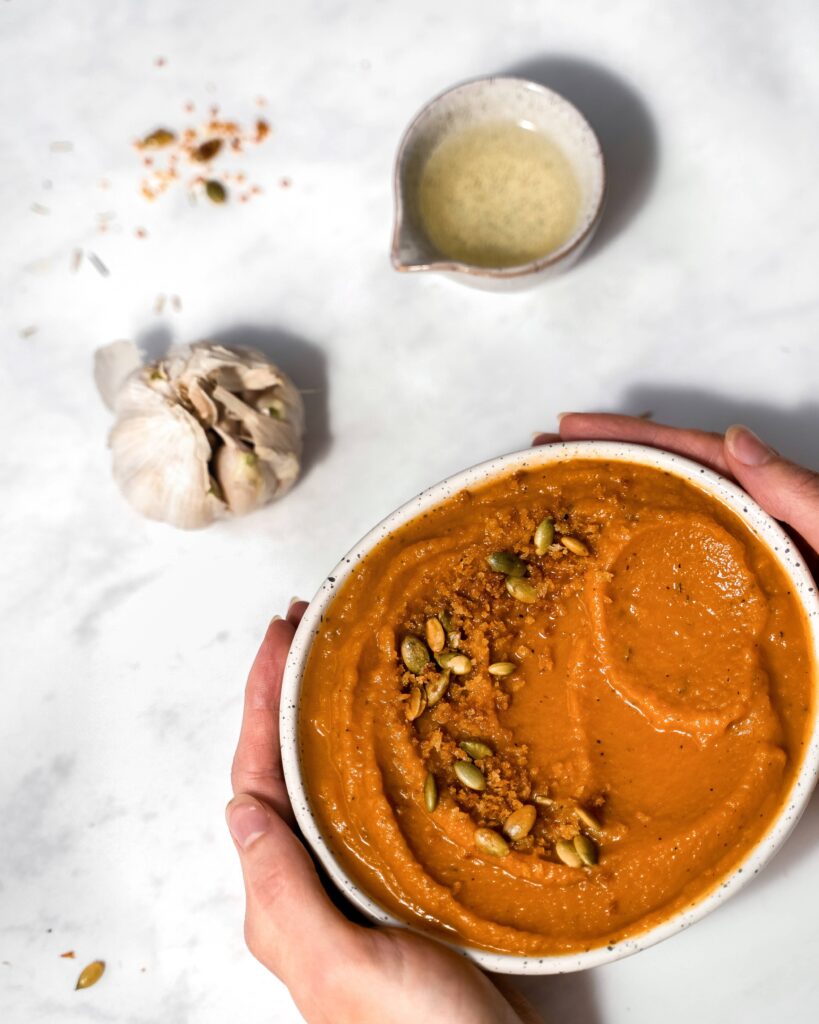 bol de soupe orange aux carottes et romarin avec gousse d'ail