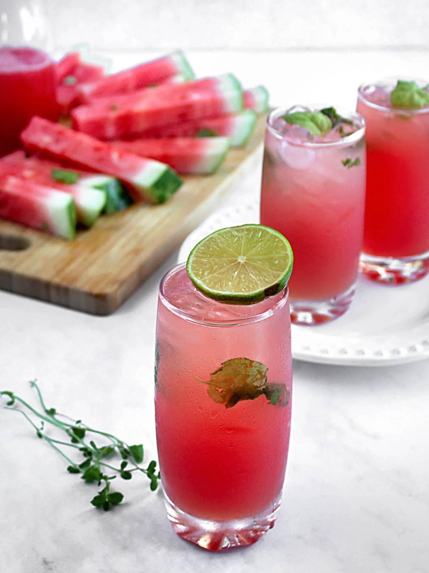 Verres rempli d'un breuvage rose avec bâtonnets de melon d'eau