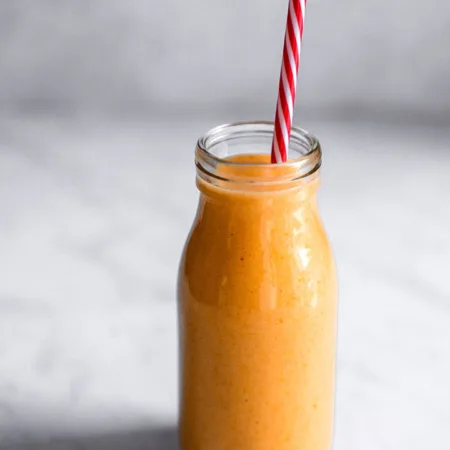 Verre de smoothie orange avec une jolie paille