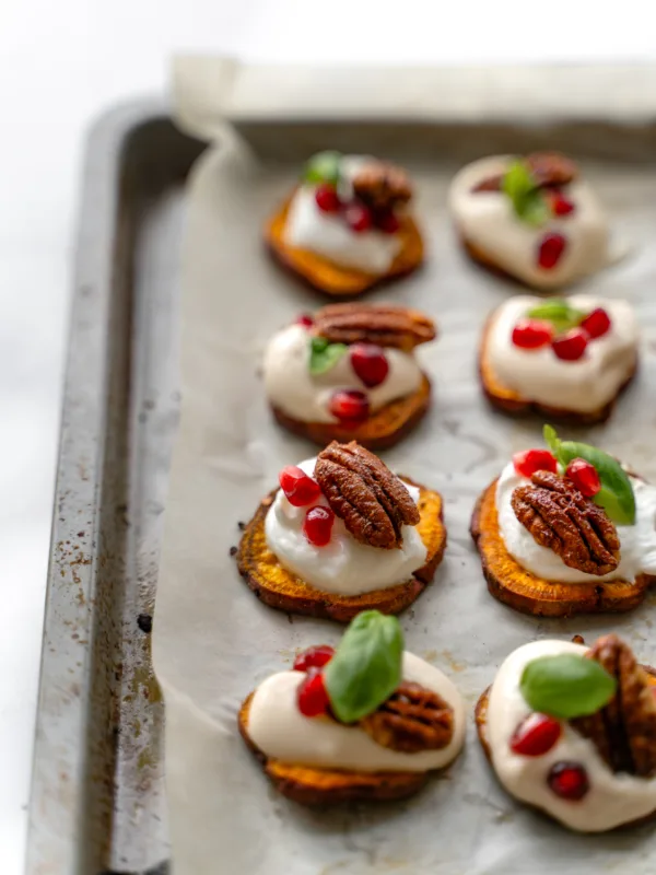 Canapé sur des patates douces avec yogourt, grenade, basilic et pacane