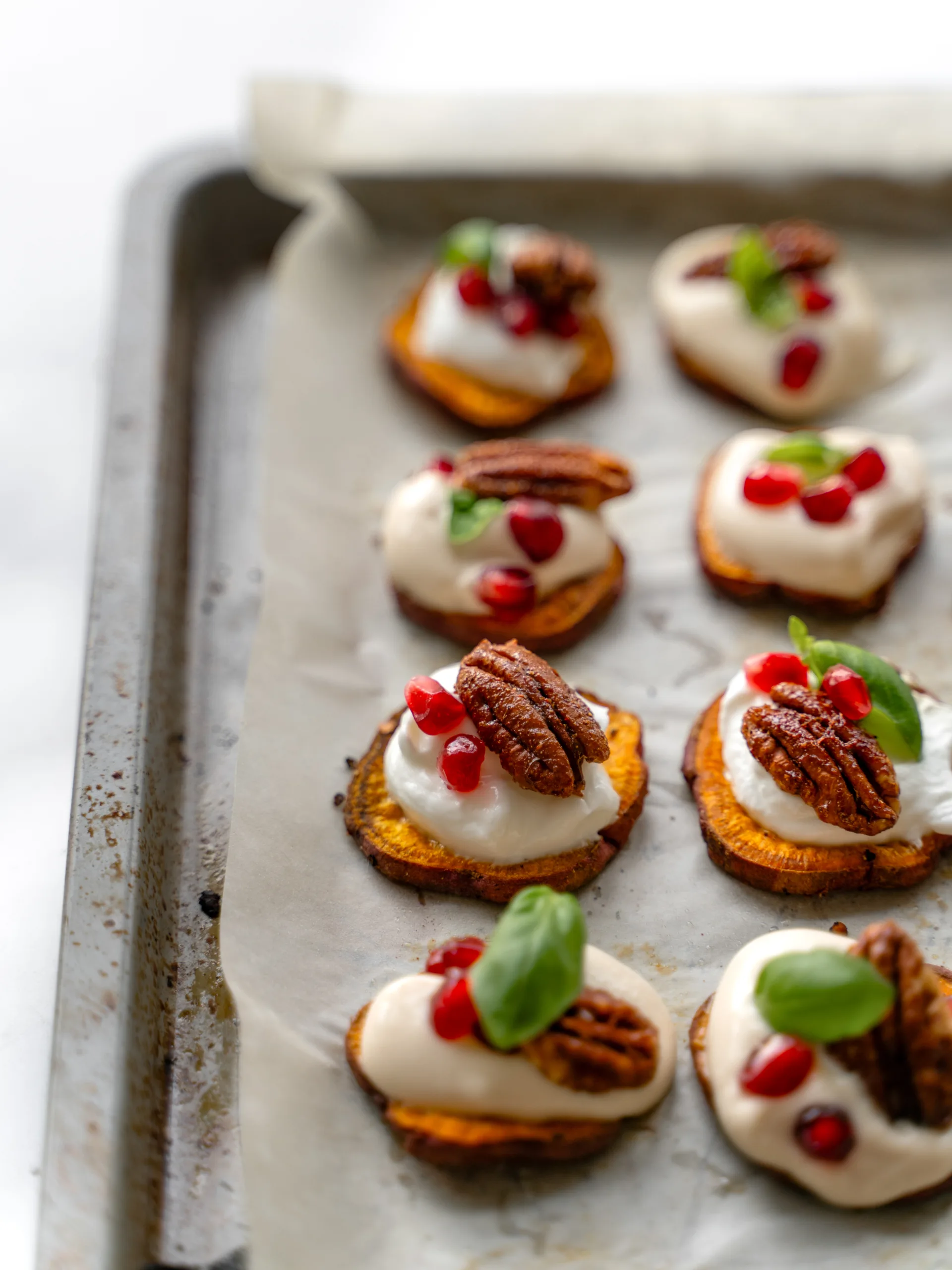 Canapé sur des patates douces avec yogourt, grenade, basilic et pacane