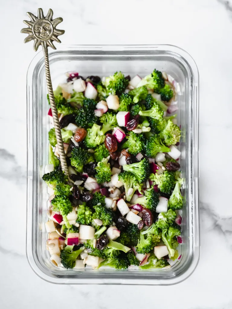 Grand bol de salade de brocoli et de pomme croquante avec tofu émietté sur le dessus