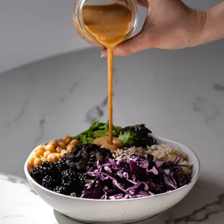 Sauce au beurre de tournesol versé sur un bol Bouddha