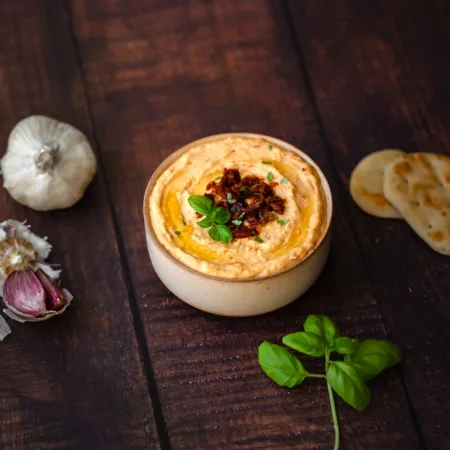 Plat de hummus maison de haricots blancs aux tomates séchées sur la table