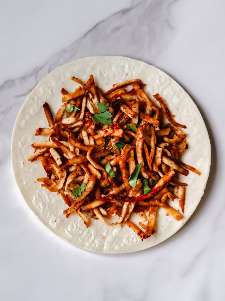Tortilla de maïs garnie de tofu effiloché et de coriandre hachée