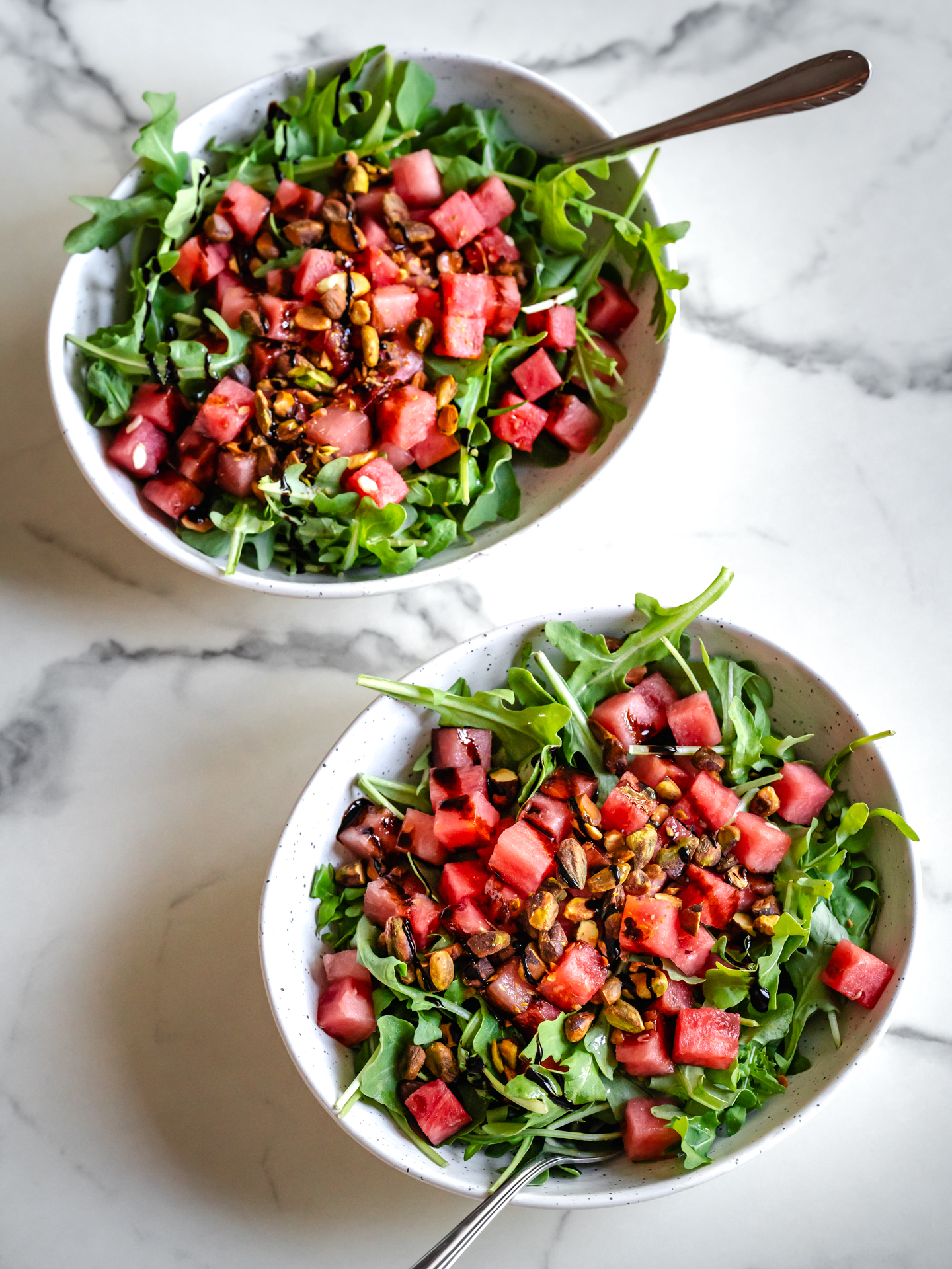 Bols de salade de melon d'eau fraîche, roquette et pistaches croustillantes